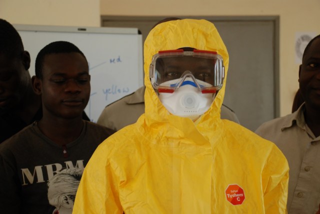 Training des Anziehens der Schutzkleidung. Im Ernstfall müssen alle Öffnungen luftdicht abgeklebt werden.