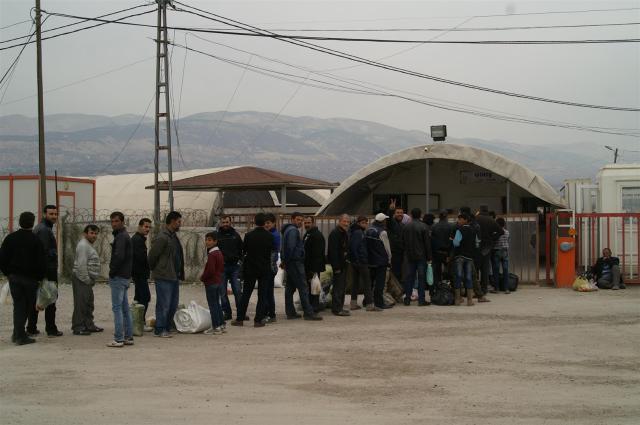 Syrian refugees are  queuing up in front of the camp entrance.